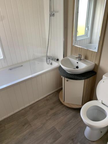 a bathroom with a tub and a sink and a toilet at Clearwater Lodge - 392 Valencia Heights in Greatstone