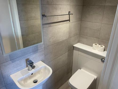 a bathroom with a sink and a toilet at The Wildings Hotel & Tudno's Restaurant in Llandudno
