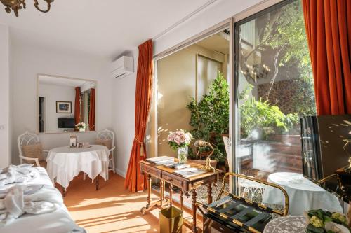 a living room with a table and a window at Hôtel Le Roquebrune in Roquebrune-Cap-Martin