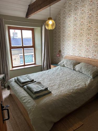 a bedroom with a bed with towels on it at Copley Cottage in Copley