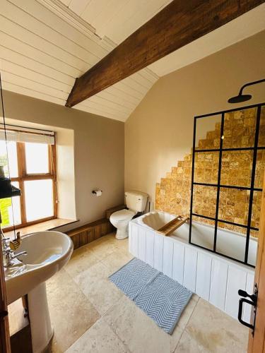 a bathroom with a tub and a toilet and a sink at Copley Cottage in Copley
