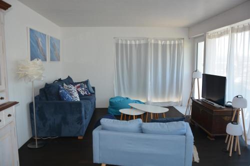 a living room with a couch and a table at Leben im Hafen am idyllischen Murtensee in Guévaux