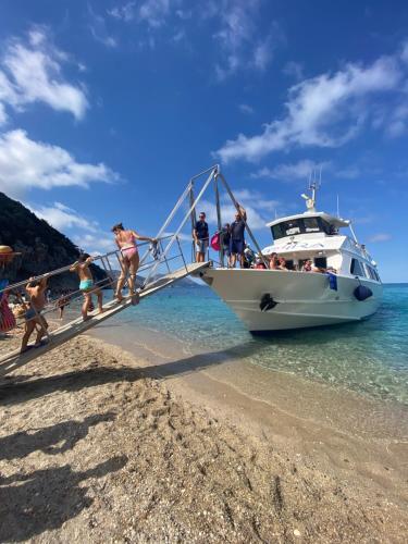 a group of people getting on a boat on the beach at Villa Federica by Etra Vacanze in Orosei