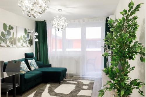a living room with a green couch and a chandelier at Sixties Elite Free Private Parking in Debrecen