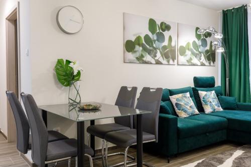 a living room with a green couch and a table at Sixties Elite Free Private Parking in Debrecen