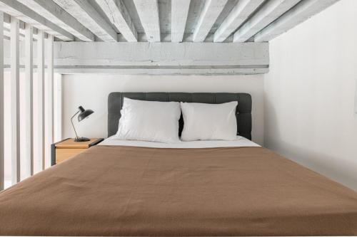 - une chambre avec un grand lit aux murs blancs dans l'établissement Le Royale Haussman Junior suite - Louis Pradel - Netflix, à Lyon