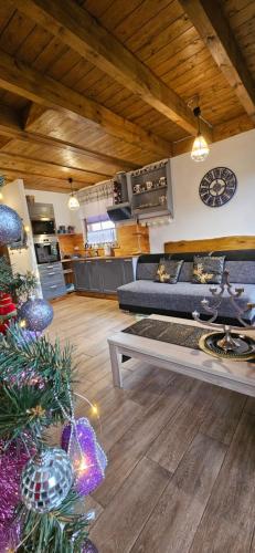 a living room with a christmas tree and a couch at Ostoja Bukowo Kaszmir 18,1 in Borowy Młyn