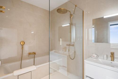 a bathroom with a shower and a tub and a sink at Hôtel Le Roquebrune in Roquebrune-Cap-Martin