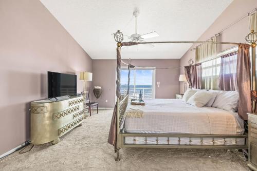 una camera da letto con letto a baldacchino e televisione di Florida Villa a Palm Harbor
