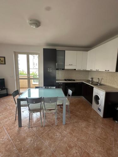a kitchen with a table and chairs in a room at Le Piante - Appartamento in residence con piscina in Gioiosa Ionica