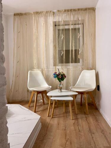 two chairs and a table in a room with a window at Central Cozy Apartment in Oradea