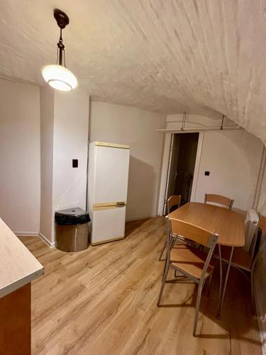 a kitchen and dining room with a table and a refrigerator at Central Cozy Apartment in Oradea