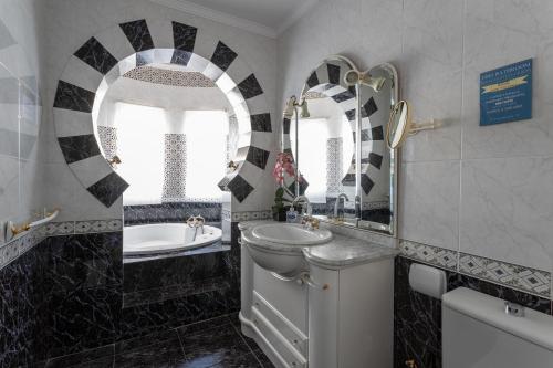 a bathroom with a sink and a toilet and a tub at Villa Nerja in Nerja