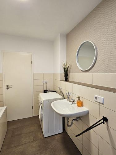 a white bathroom with a sink and a mirror at Bördeapartment am Heiderand 2 in Samswegen