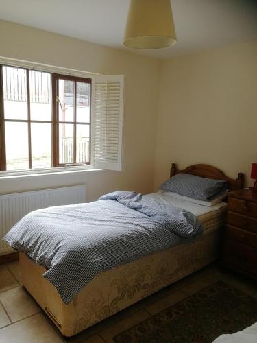 a bedroom with a bed and a window at Dovehouse Farm Barns in Kingsey