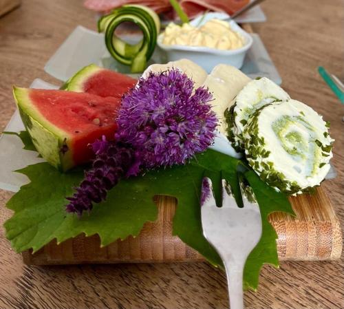 a plate of different types of cheese and a fork at Gutshaus Krimvitz kleines Doppelzimmer im Obergeschoss inklusive Frühstück in Putbus