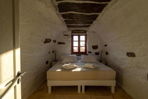 a bedroom with a bed in a room with a window at Petra Vista Retreats in Otzias