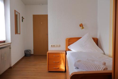 a small bedroom with a bed and a night stand at Weinhaus Hirschen Bruttig in Bruttig-Fankel