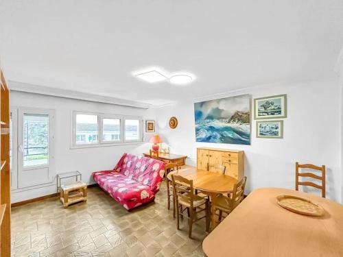 a living room with a red couch and a table at Maison charmante à Saint-Herblain avec jardin privé in Saint-Herblain