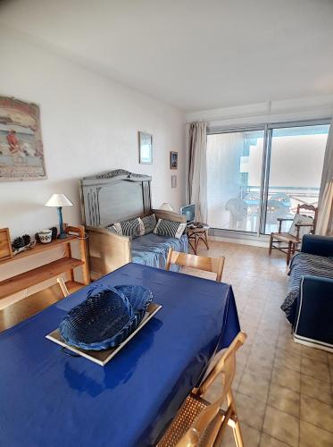 - un salon avec une table bleue et un canapé dans l'établissement appartement en frond de mer, à Soulac-sur-Mer