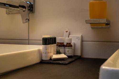 a bathroom counter with bottles of essential oils and a sink at Hotel Garni Monte Bianco in Ischgl