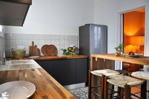 a kitchen with a counter with stools in it at Casa Castelo, Unique Flat w pool in Taviras Historical Centre in Tavira