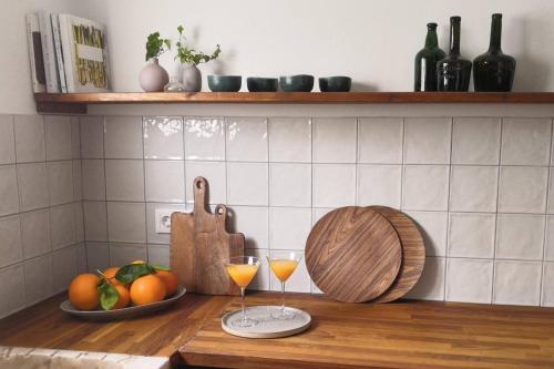 a counter with two glasses of wine and a bowl of fruit at Casa Castelo, Unique Flat w pool in Taviras Historical Centre in Tavira