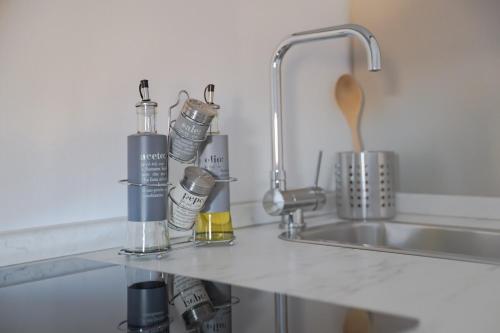 a kitchen counter with bottles and a sink at D'Annunzio Apartment in the heart of Navigli in Milan