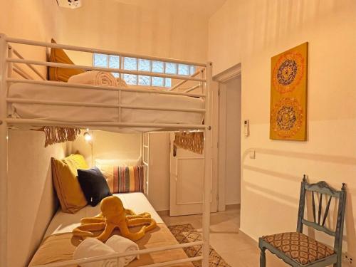 a bedroom with a bunk bed and a chair at Casa Alice - Olhão in Olhão