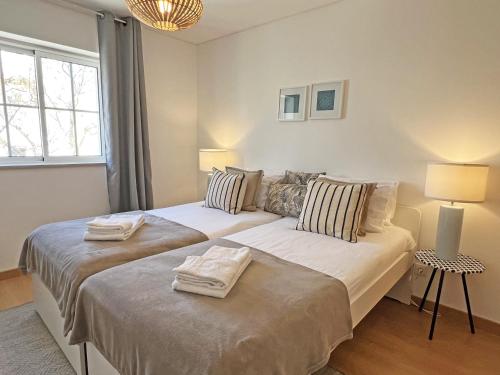a bedroom with two beds with towels on them at APF Beach T2 Cabanas Home by Junto ao Mar in Cabanas de Tavira