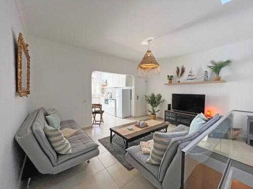 a living room with two couches and a table at Casa Alice - Olhão in Olhão