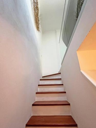 a staircase in a house with white walls and wooden floors at Casa Alice - Olhão in Olhão