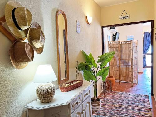a room with a table with a lamp and a mirror at A Minha Casinha - Marim Olhão By Junto ao Mar in Moncarapacho