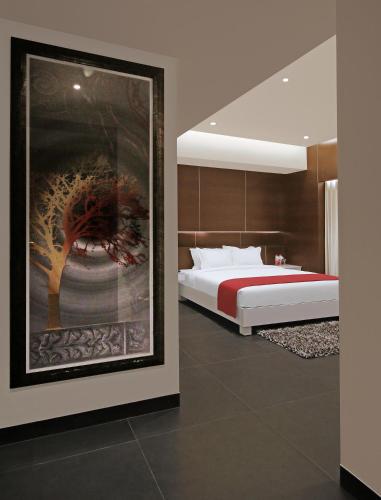 a bedroom with a bed and a painting on the wall at Hotel German Palace Near to Airport in Gandhinagar