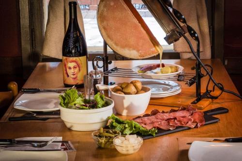 a table topped with food and a bottle of wine at Magnifique VUE LAC et SKI in Mont-Tremblant