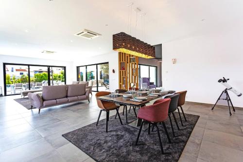 a living room with a dining table and chairs at Blue Hill Boutique Villa by Junto ao Mar in Quelfes