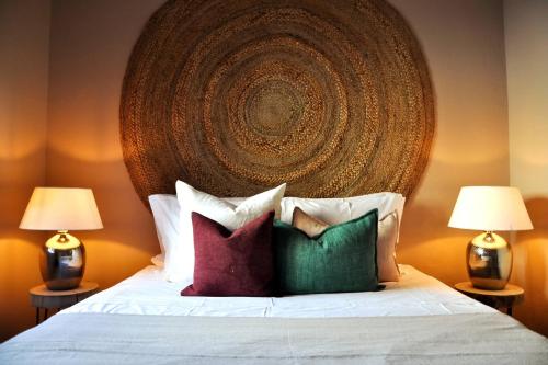 a bedroom with a bed with pillows and a large headboard at Casa Salinas, Elegant Flat w patio in Taviras Historical Centre in Tavira