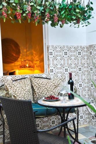 a table with a bottle of wine and a glass at Casa Salinas, Elegant Flat w patio in Taviras Historical Centre in Tavira