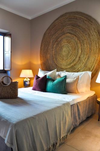 a bedroom with a large bed with colorful pillows at Casa Salinas, Elegant Flat w patio in Taviras Historical Centre in Tavira
