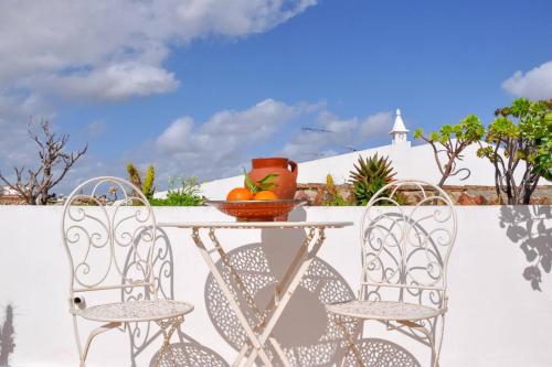 a table with two chairs and a bowl of fruit on it at Elegant Studio Formosa in Taviras Historica Centre in Tavira