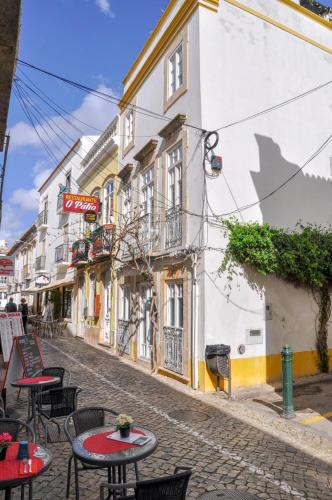 a street with tables and chairs on a cobblestone street at Elegant Studio Formosa in Taviras Historica Centre in Tavira