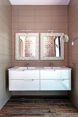 a bathroom with two sinks and two mirrors at Blue Hill Boutique Villa by Junto ao Mar in Quelfes