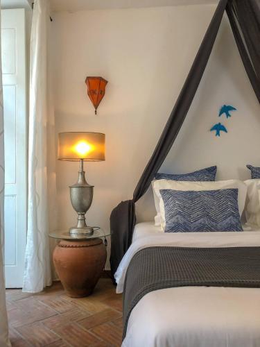 a bedroom with a bed and a lamp and bats on the wall at Stylish Studio Gilao in Taviras Historical Centre in Tavira