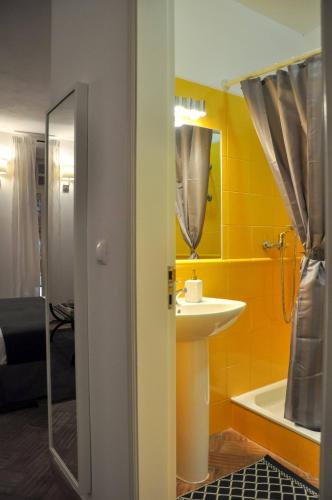 a bathroom with a sink and a mirror and a tub at Stylish Studio Gilao in Taviras Historical Centre in Tavira