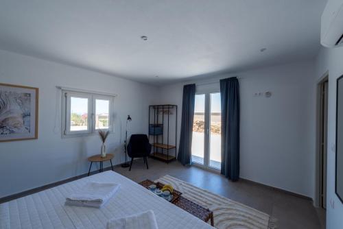 a white bedroom with a bed and a window at Petra Vista Retreats in Otzias