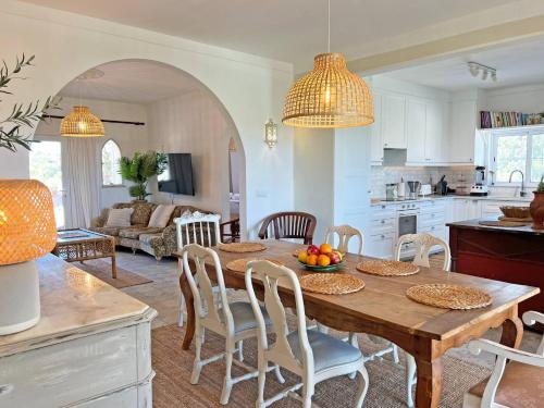 a kitchen and living room with a wooden table and chairs at Casa BelaVista - Fuzeta in Moncarapacho