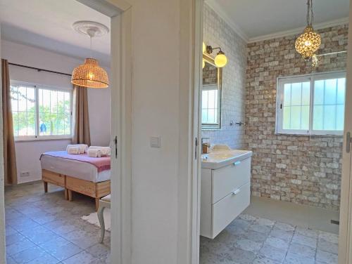 a bathroom with a bed and a sink in a room at Casa Belavista - Fuzeta by Junto ao Mar in Moncarapacho