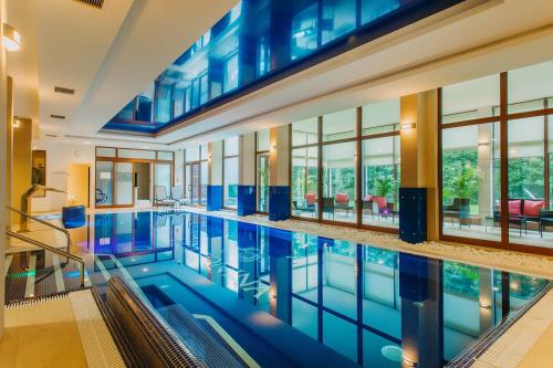 duży basen w budynku z oknami w obiekcie Cottonina Hotel & Mineral SPA Resort w Świeradowie Zdroju