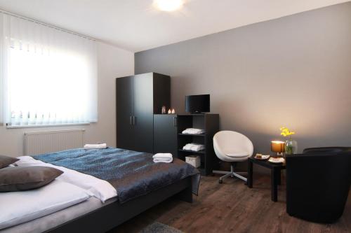 1 dormitorio con cama, escritorio y silla en JBI Wellness, en Kolín
