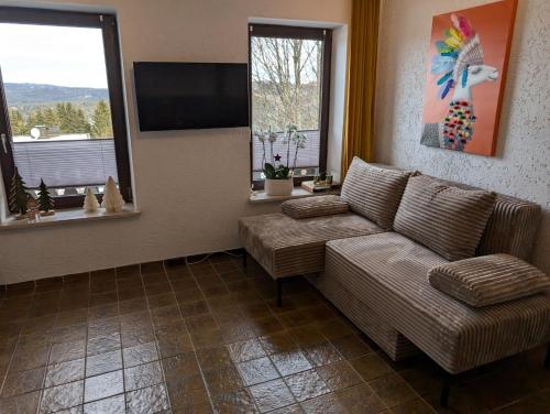 a living room with a couch and a flat screen tv at Ferienwohnung am Almberg in Philippsreut